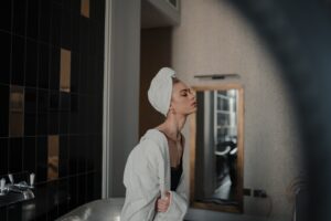 woman in white robe standing in front of mirror
